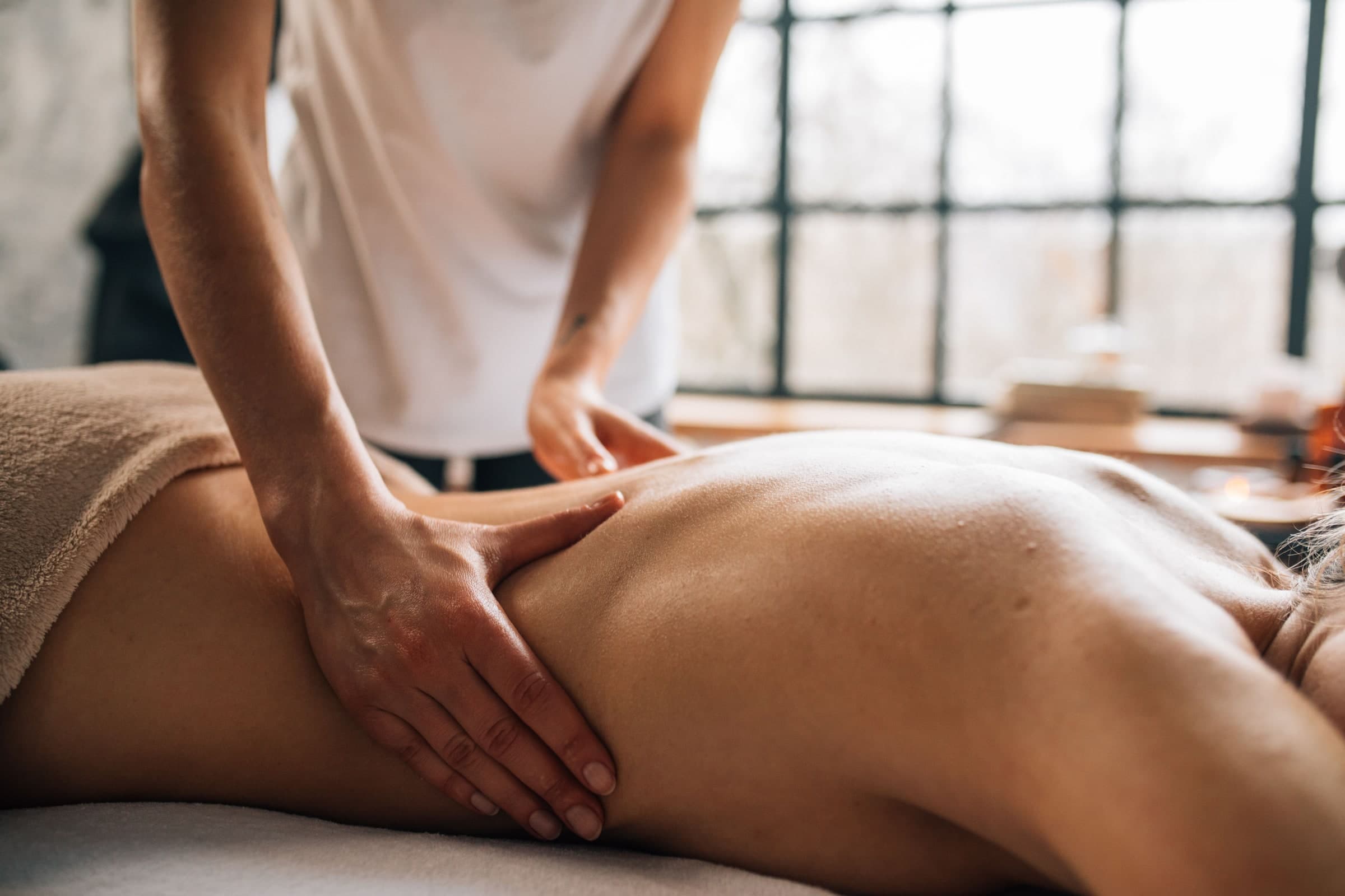Massage therapist performing soft tissue work on a client's leg at a wellness clinic in Toronto