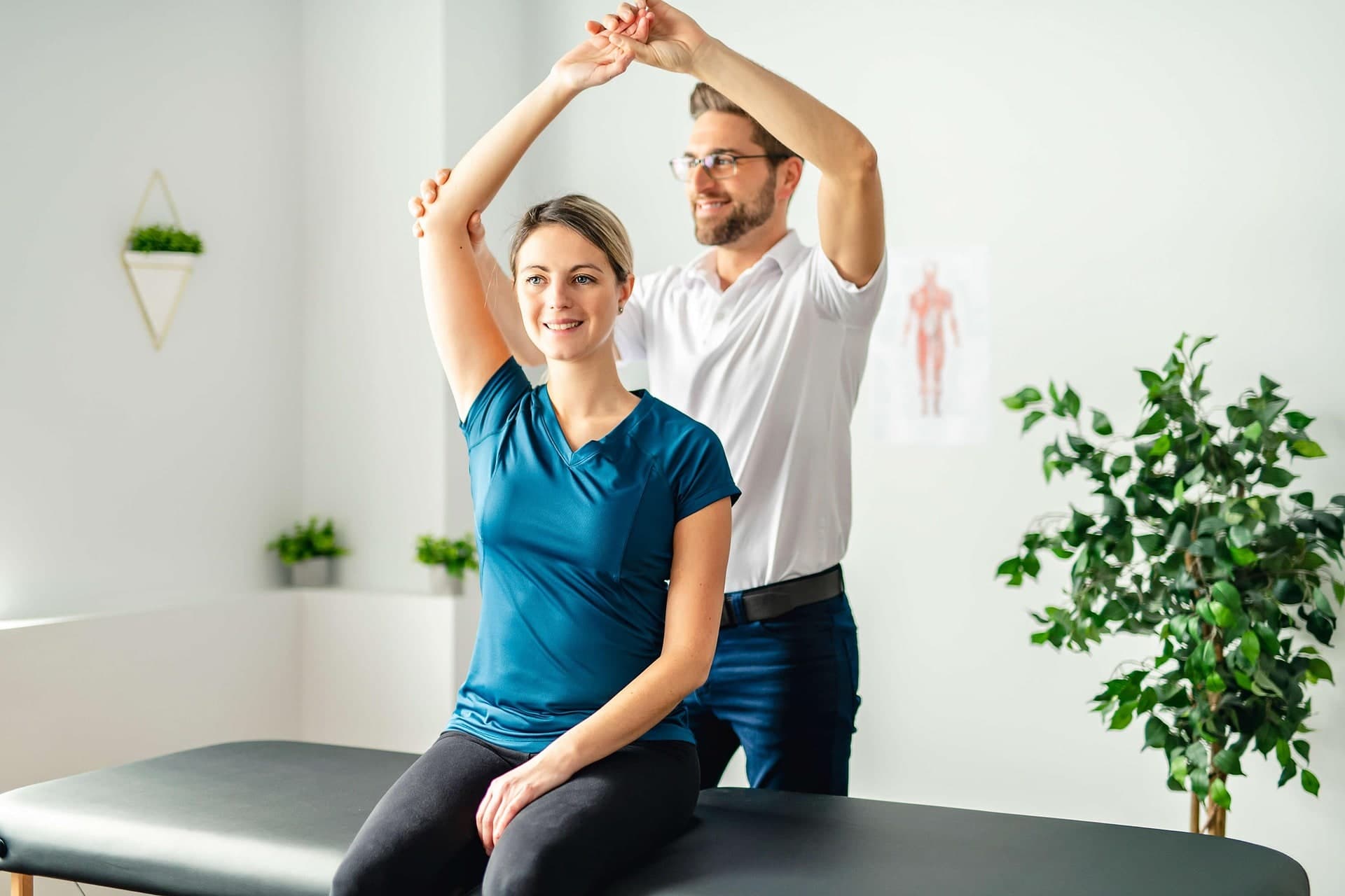 A physiotherapist guiding a patient through a stretching exercise in a bright clinical treatment room in Toronto
