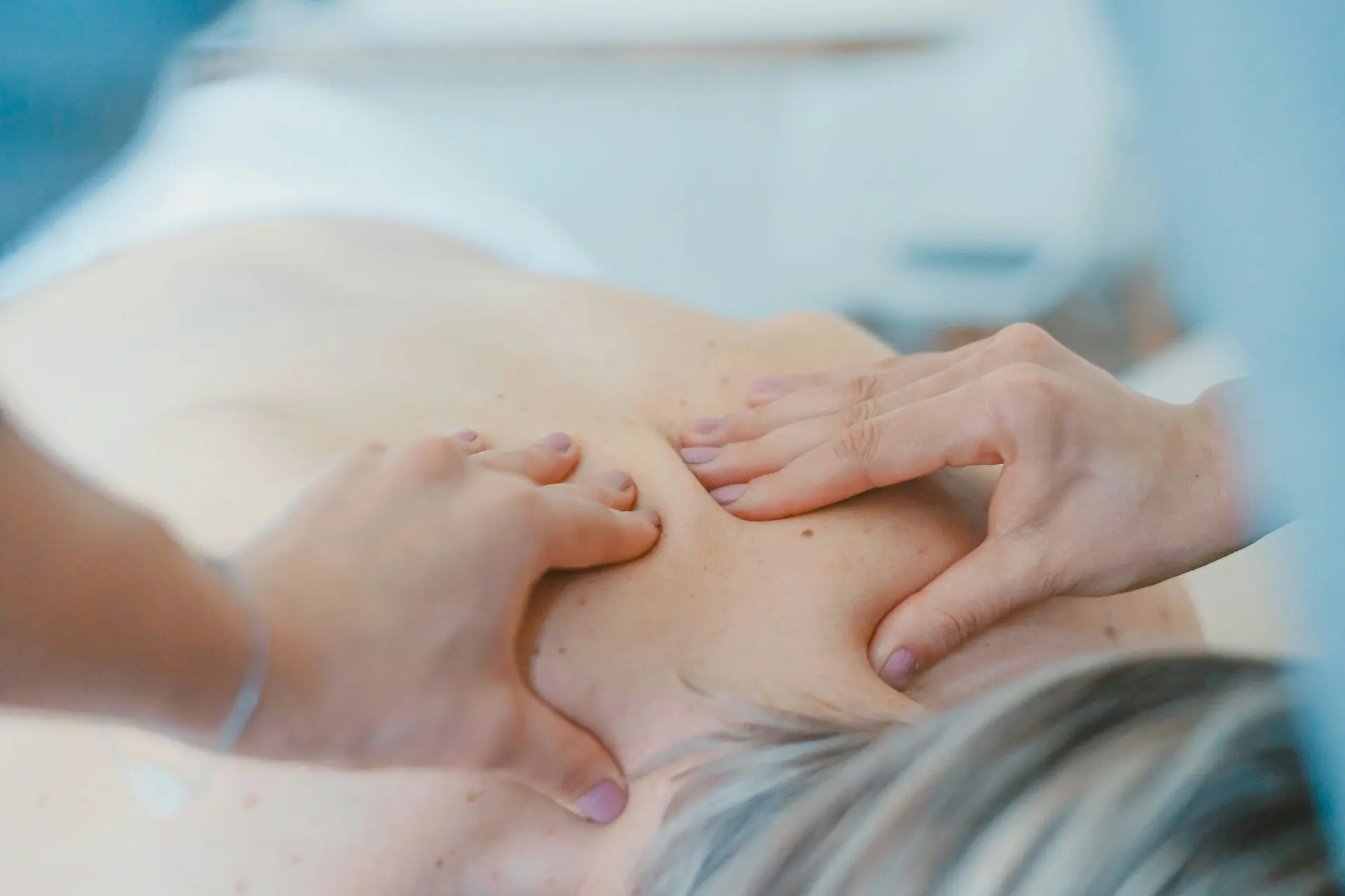 A therapist providing manual treatment to the upper back
