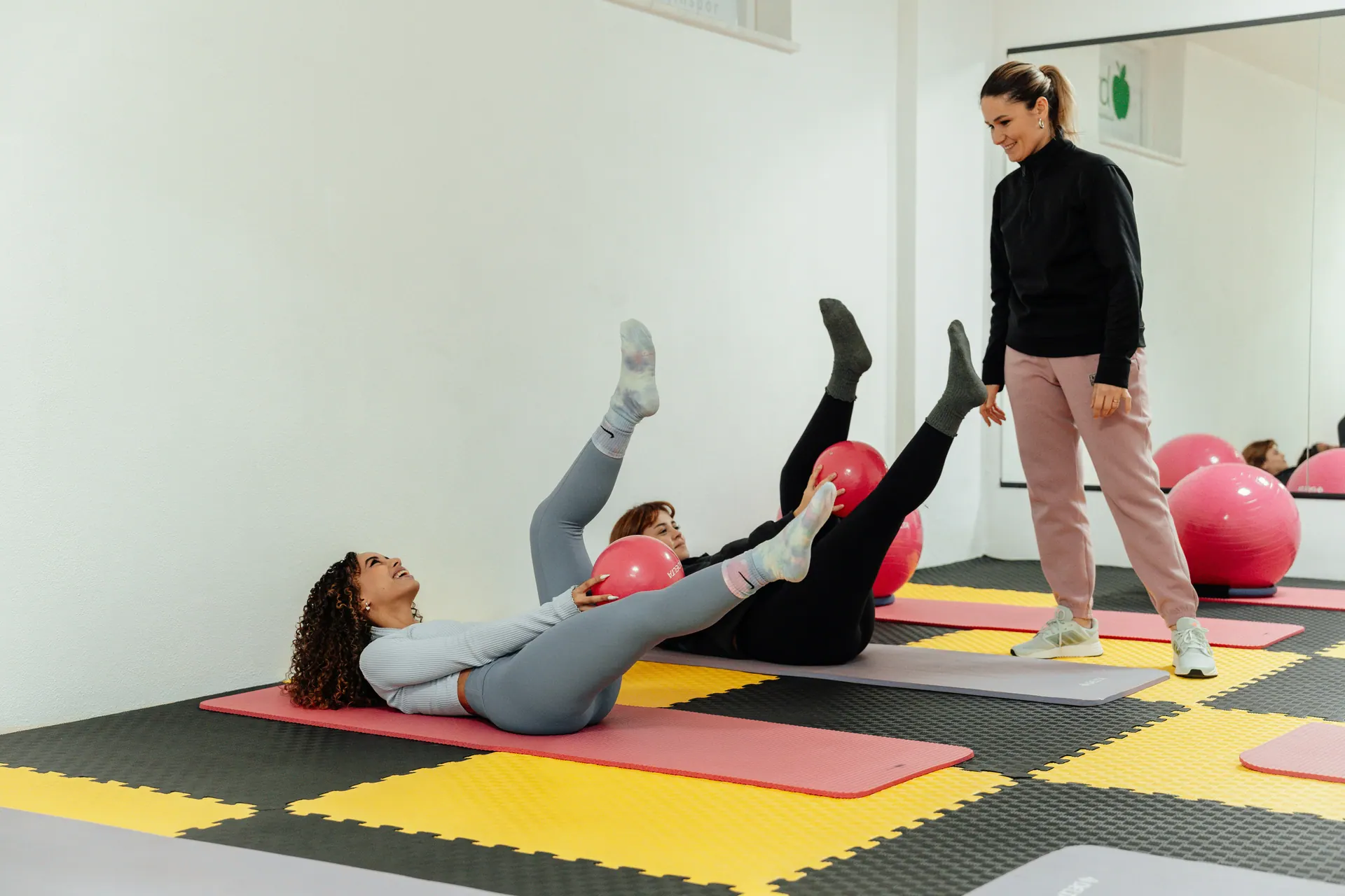 A physiotherapist guiding a small group through floor exercises