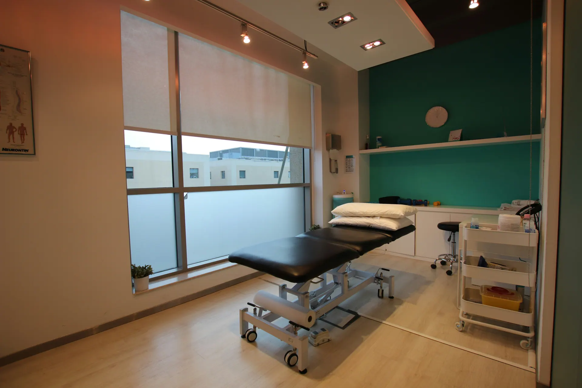 A bright treatment room with a teal feature wall